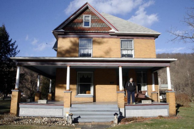 Scott Lloyd stands on the front porch of his home which is the house used as the home of psychotic killer Buffalo Bill in the 1991 film "The Silence of the Lambs" on Monday, Jan. 11, 2016 in Perryopolis, Pa. Scott and Barbara Lloyd listed the house for sale last summer, but they've dropped the asking price from $300,000 to $250,000. The three-story Victorian was the second-most clicked home on Realtor.com last year, but no serious buyers. (AP Photo/Keith Srakocic)